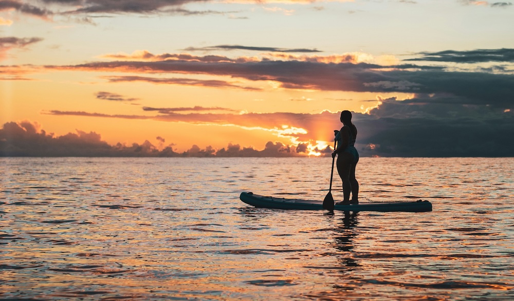 stand up paddleboarding in the sunset